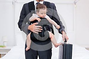 Midsection of father carrying baby while holding briefcase photo