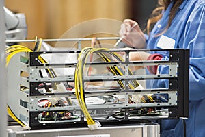 Midsection of female engineer repairing computer part in electronics industry