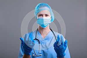 Midsection of female surgeon reaching for surgical scissors in operating theatre