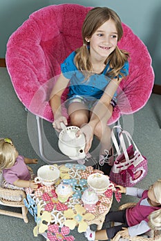 Midsection of girl pretending to have tea party with her dolls