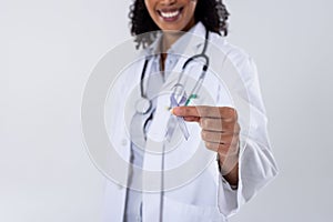 Midsection of happy african american mid adult female doctor with white lung cancer awareness ribbon