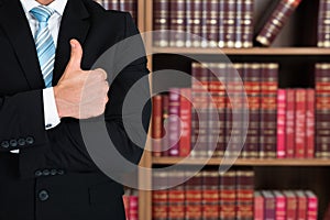 Midsection Of Lawyer Gesturing Thumbs Up