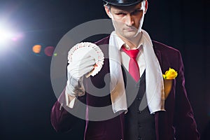 Midsection of magician showing fanned out cards against black background. Magician, Juggler man, Funny person, Black