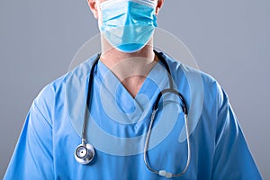 Midsection of male surgeon wearing protective clothing in operating theatre