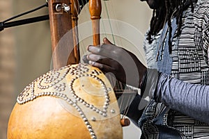 Midsection of man playing kora lute
