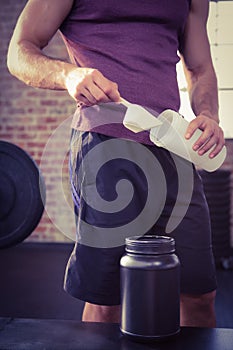 Midsection of man putting supplement into bottle photo