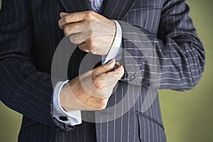 Midsection Of Man In Suit Buttoning Cuff Sleeves