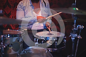 Midsection of musician playing drum kit