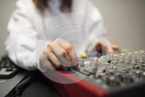 Midsection Of Radio Host`s Hand Using Music Mixer In Studio