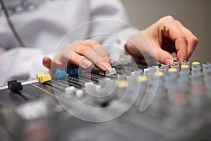 Midsection Of Radio Host`s Hands Using Music Mixer In Studio