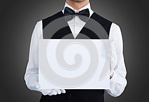 Midsection of waiter holding blank billboard