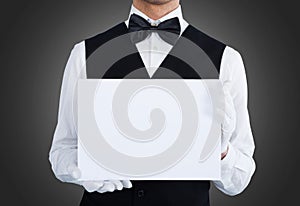 Midsection of waiter holding blank billboard photo