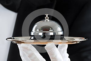 Midsection Of Waiter Holding Service Bell In Plate