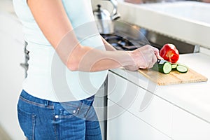 Midsection of woman cutting vegetables