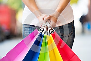 Midsection Of Woman Holding Colorful Shopping Bags