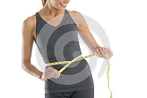 Midsection Woman Smiling While Measuring Her Waistline photo
