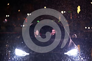 In the midst of a nighttime journey, a happy family enjoys playful moments inside a car as they travel through rainy