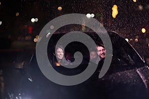 In the midst of a nighttime journey, a happy family enjoys playful moments inside a car as they travel through rainy