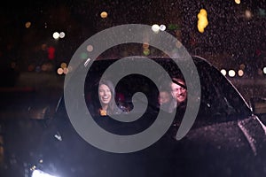 In the midst of a nighttime journey, a happy family enjoys playful moments inside a car as they travel through rainy