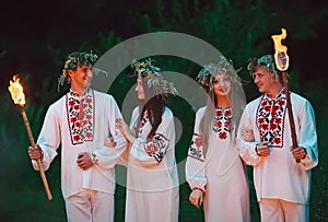 Midsummer. Young people in the same Slavic costumes are holding torches with fire