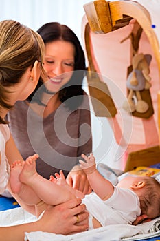 Midwife examining newborn baby