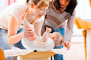 Midwife measuring weight or newborn baby