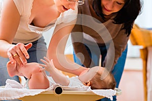 Midwife measuring weight or newborn baby