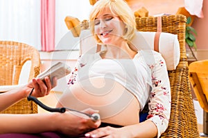 Midwife seeing mother for pregnancy examination