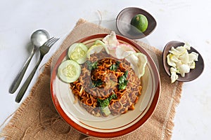 mie tek tek or fried noodle made with egg noodles with chicken, cabbage, mustard greens, meatballs, scrambled eggs. indonesian.