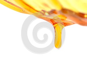 Miel coulant vers le bas d`une cuillÃÂ¨re de miel sur un fond foncÃÂ© Macro. photo