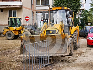 Parking  JCB and Volvo excavators in the small town.