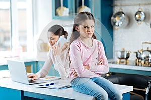 Miffed little girl sitting on the table