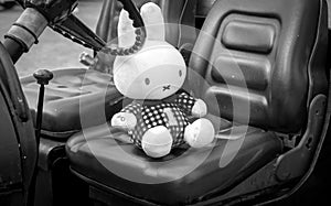 Miffy doll on a carseat in black and white