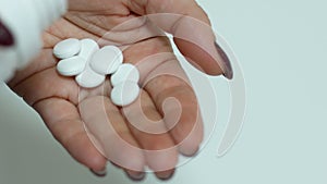 Migraine headache torments woman theme. The woman pours a handful of pain-relieving pills into her palm. Healthy Vitamin Supplemen