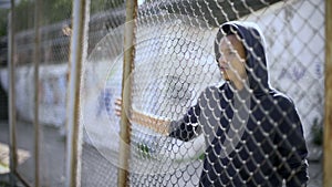 Migrant child separated from family, afro-american boy behind fence, detained photo