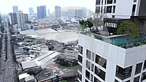Migrant Sitting On A Luxurious Hotel Rooftop With Sight Of Urban Landscape And Modern High-rise Buildings In Bangkok
