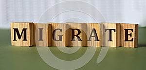 MIGRATE - word on wooden blocks on light background photo