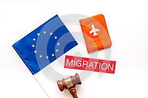 Migration to Europa concept. European flag near passport and judge hammer on white background top-down