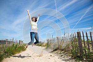 Miidle aged woman jumping on the beach