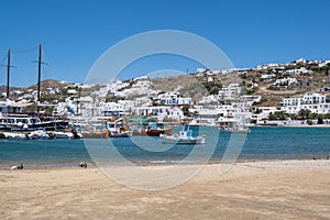 Mikonos island, Cyclades, Greece. Mykonos port moored boat, building, blue sky background photo