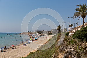 Mil Palmeras beach Costa Blanca Spain with palm trees and holidaymakers with parasols in beautiful summer weather photo