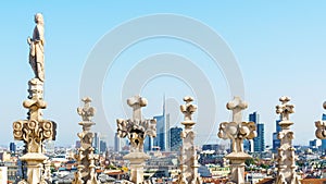 Milan cityscape through sculptures on the roof of Duomo cathedral. photo