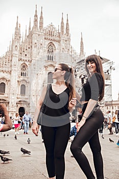 Milan, Italy - May 16, 2018: Two girls strolling towards Duomo Square and Vittorio Emanuele II galleries in Italy, Milan at
