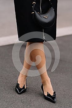 Milan, Italy - September, 21, 2023: woman wears black brushed leather pumps, high heels from Prada .