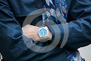 Man with Breitling watch with blue dial and blue coat before Giorgio Armani fashion show, Milan Fashion Week