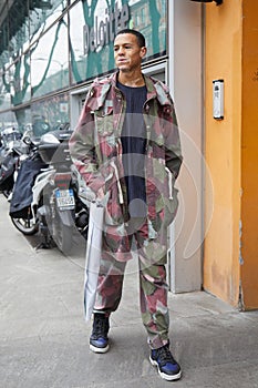 Man with green, gray and dark red camouflage jacket and trousers before Giorgio Armani fashion show, Milan