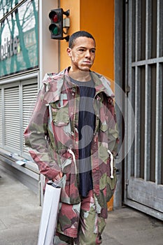 Man with green, gray and dark red camouflage jacket and trousers before Giorgio Armani fashion show, Milan