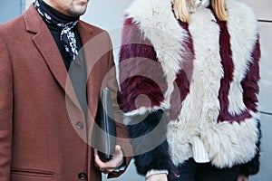 Man and woman with brown jacket and dark red and white fur before N 21 fashion show, Milan Fashion Week street