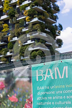 Milan, Lombardy, Italy - MAY, 5, 2024: the BAM - Biblioteca degli Alberi park sign with the Bosco Verticale in the background photo