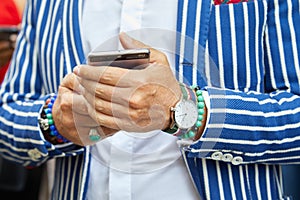Man with Smart Tornout watch, turquoise bracelet and blue and white striped jacket before Ermanno Scervino